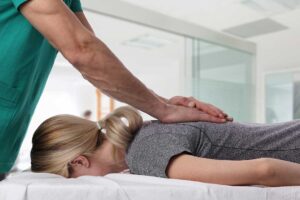 A chiropractor gently examining an adult patient’s neck and upper back in a calm clinical setting.
